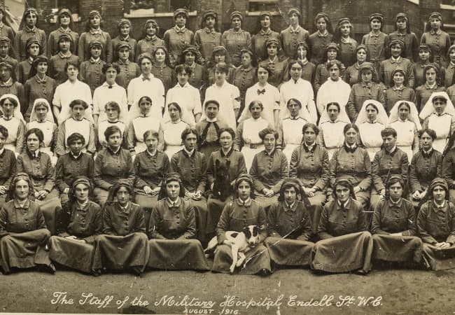 The staff of Endell Street Military Hospital line up for a photo taken in black and white. There are around 50 people in the photograph