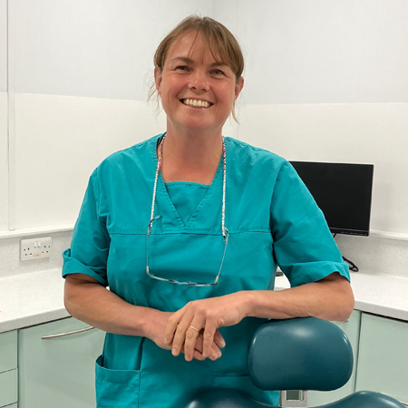 Julia Hallam Seagrave wearing turquoise scrubs smiling towards the camera