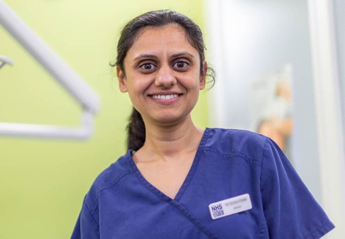 BDA Elections Ad A female dentist wearing a blue dental top smiling towards the camera