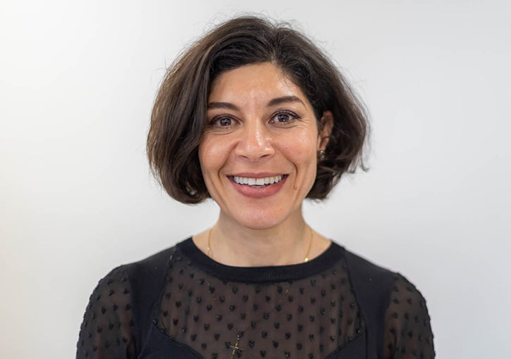 A female dental practice owner smiling into the camera