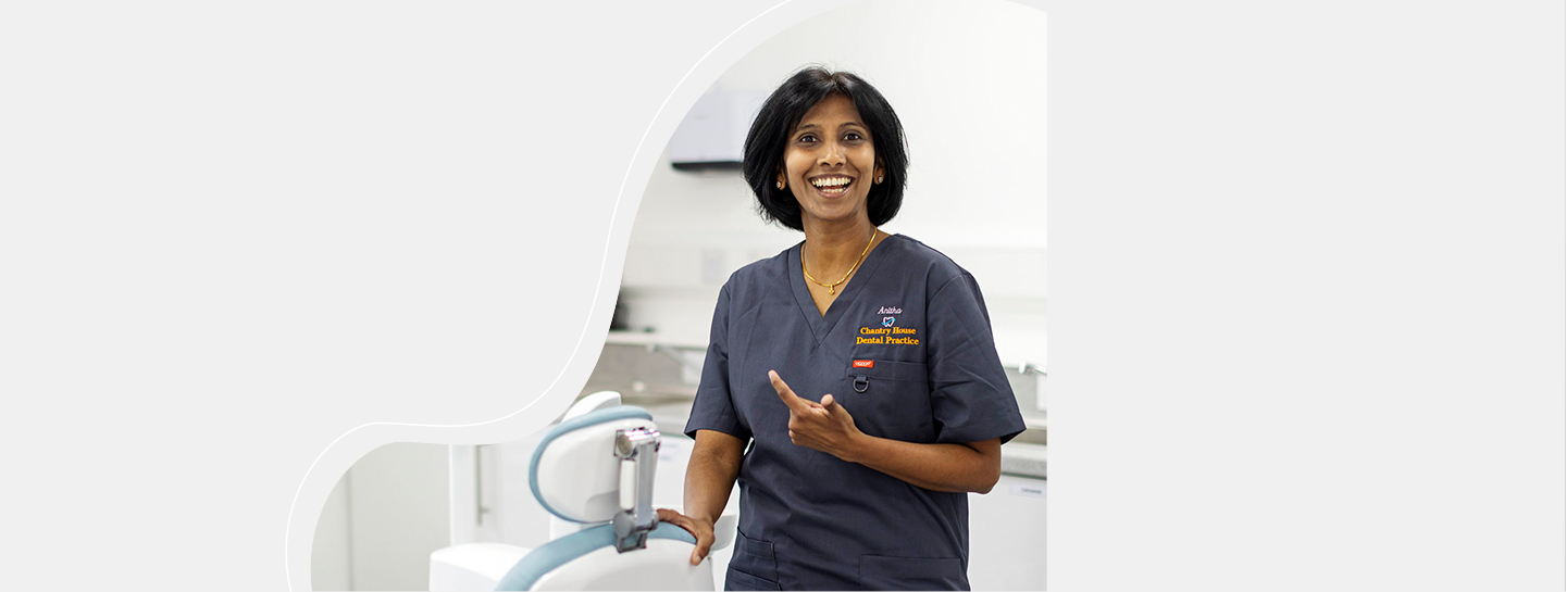 A female dentist in her practice smiling into the camera
